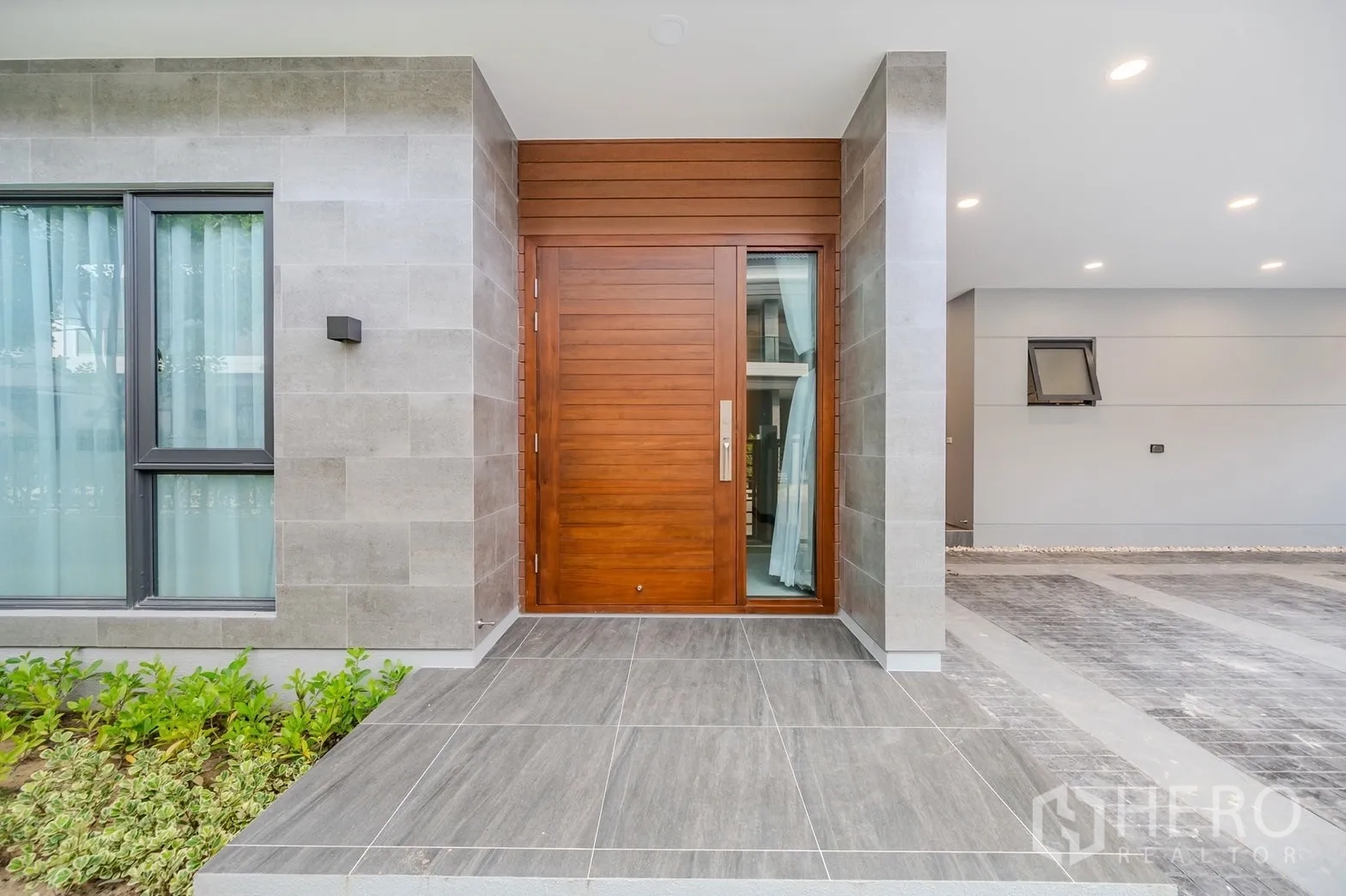Detached House for rent in Bang Phli, Samut Prakan - Wide wooden front door on tiled porch with grey stone cladding