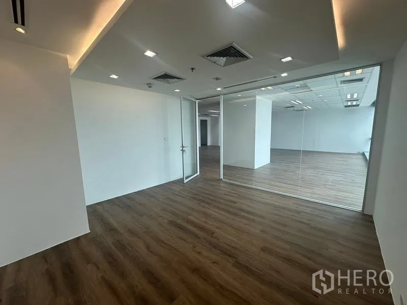 สำนักงาน ให้เช่า - ห้องประชุมส่วนตัว ไฟฝ้าซ่อน ผนังกระจก และพื้นลายไม้.