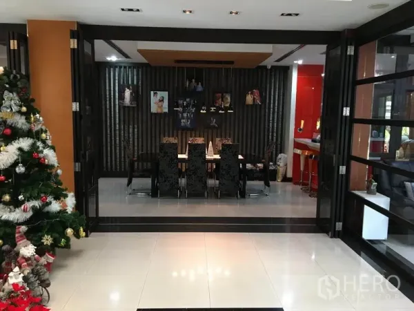 独立式住宅 出租在Khlong Toei, Bangkok - 正式餐厅，长餐桌与软包椅，吊灯照明，折叠玻璃门相连。