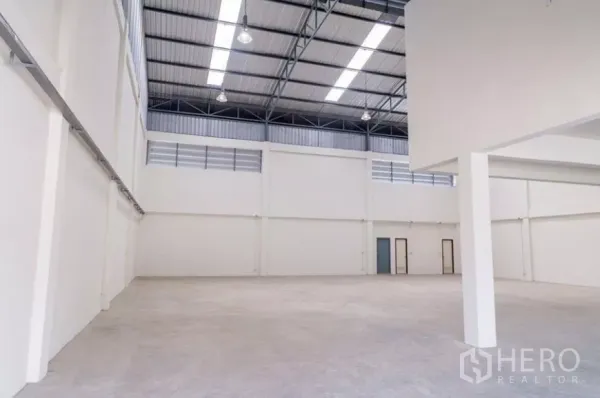 Factory for rent in Phra Samut Chedi, Samut Prakan - Open production floor with smooth concrete, tall white walls and natural light.