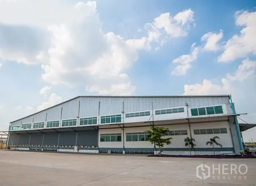 Warehouse for rent in Phra Nakhon Si Ayutthaya - Modern warehouse exterior with attached office block and spacious paved yard.