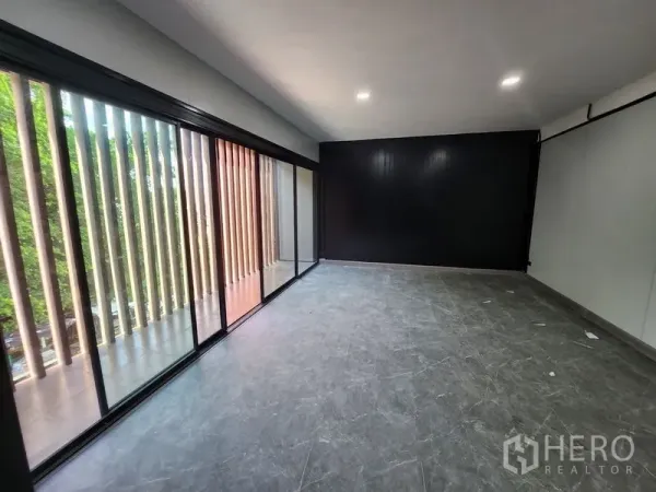 Warehouse for rent in Lam Luk Ka, Pathum Thani - Bright office room with floor-to-ceiling glass and a black feature wall.