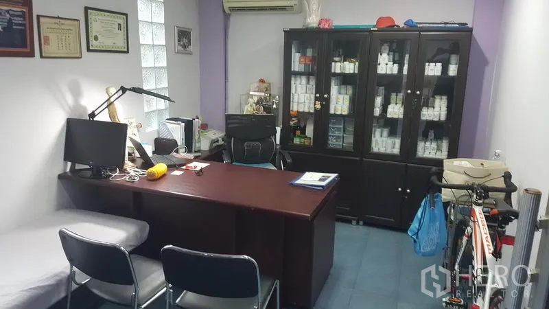 Shophouse for sale in Khlong Toei, Bangkok - Office room featuring executive desk, chairs, glass display cabinets and wall certificates.