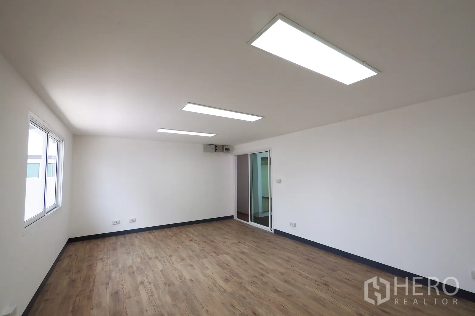 Office Space for rent in Khlong Toei, Bangkok - Bright open-plan office with wood-look flooring, white walls and LED ceiling panels.