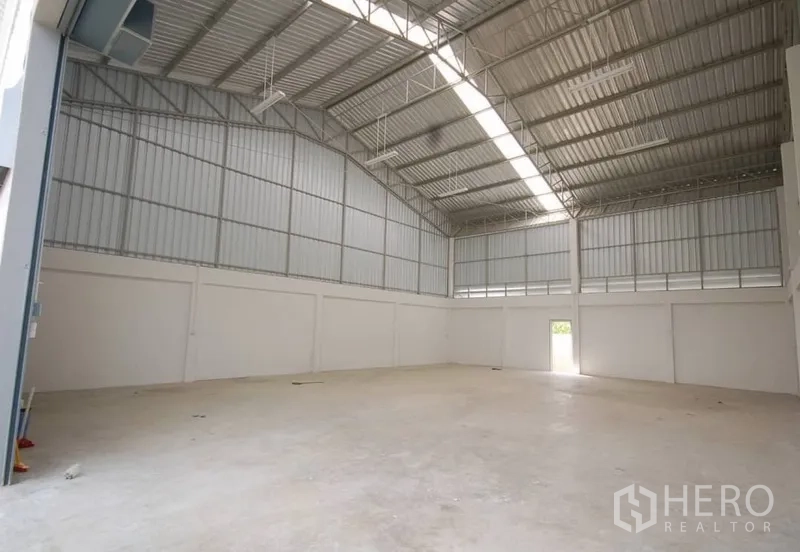 货栈 出租在Nonthaburi - 通透明亮的仓库，抛光混凝土地面、山墙屋顶及侧门。
