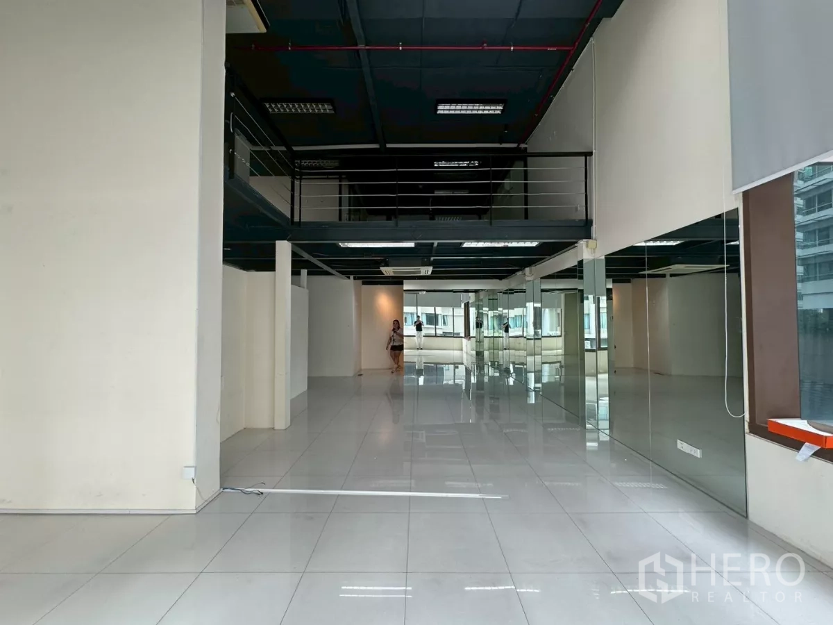 Office Space for rent in Khlong Toei, Bangkok - Long view across open space toward mirrored partitions and the mezzanine level.
