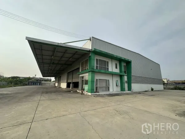 工厂 出租在Mueang Samut Prakan, Samut Prakan - 工厂侧视图，宽敞车道、深挑雨棚和多处装卸门。