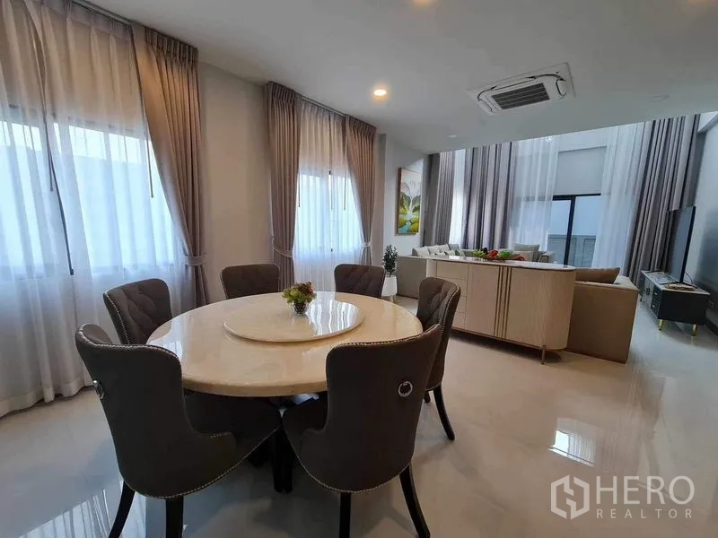 Detached House for rent or sale in Bang Phli, Samut Prakan - Dining area with round table and six chairs next to bright windows.