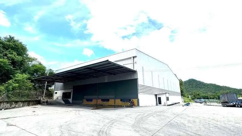 Warehouse for rent in Si Racha, Chon Buri - Large free-zone warehouse exterior with covered loading dock and wide concrete yard in Si Racha.