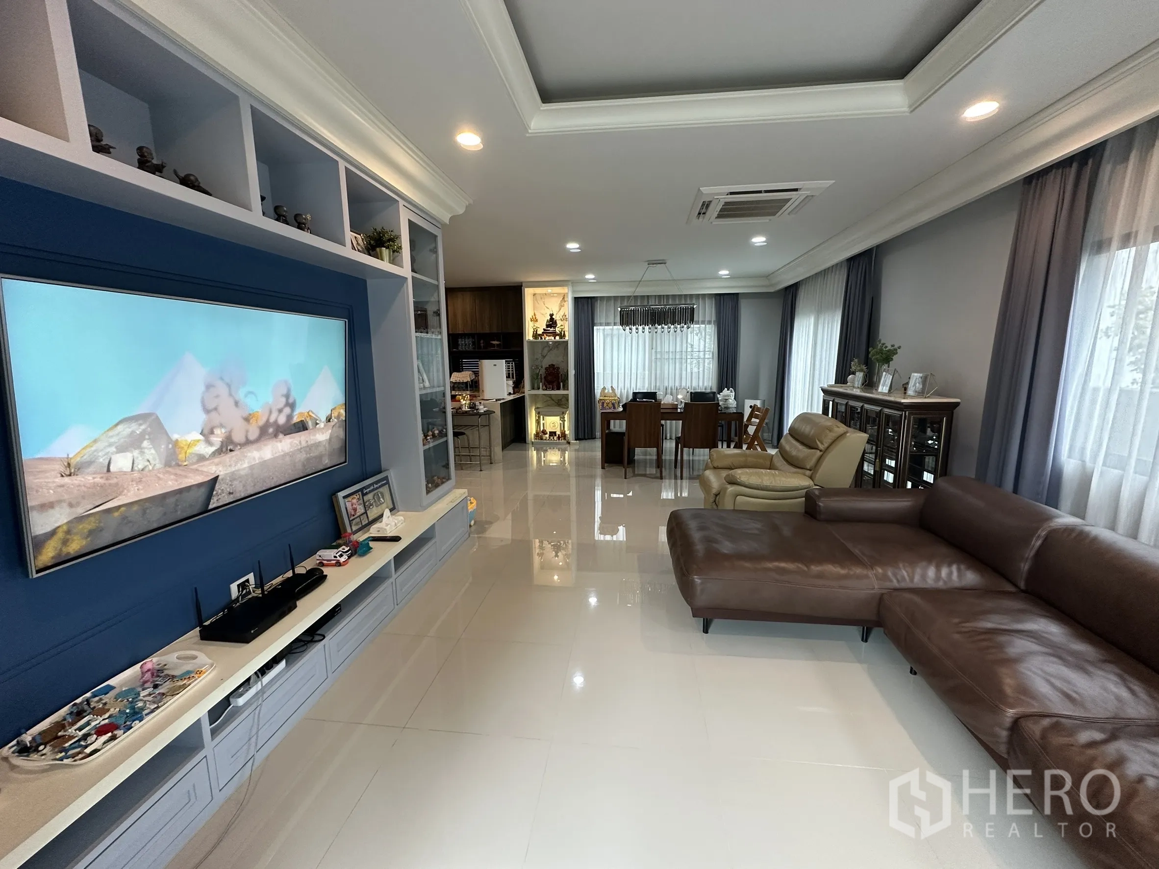Detached House for rent in Lam Luk Ka, Pathum Thani - TV wall close-up with shelving facing open dining space.
