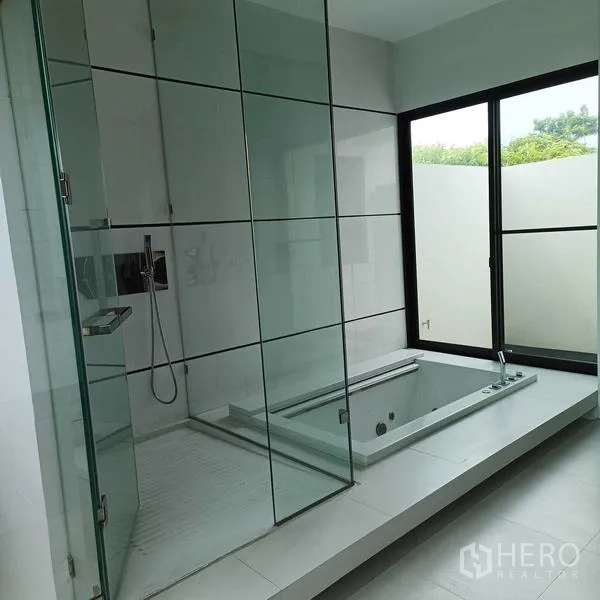 Detached House for rent or sale in Mueang Nonthaburi, Nonthaburi - Luxury bathroom featuring a glass-enclosed shower and a sunken bathtub beside a window.
