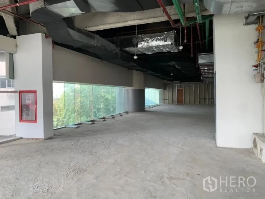 Retail Space for rent - Wide shell retail area with panoramic glass walls and a high exposed ceiling.