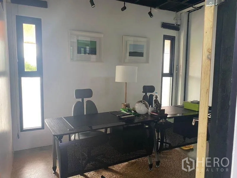 Home Office for rent or sale in Bang Khae, Bangkok - Private executive office with twin desks, wall art and tall narrow windows.