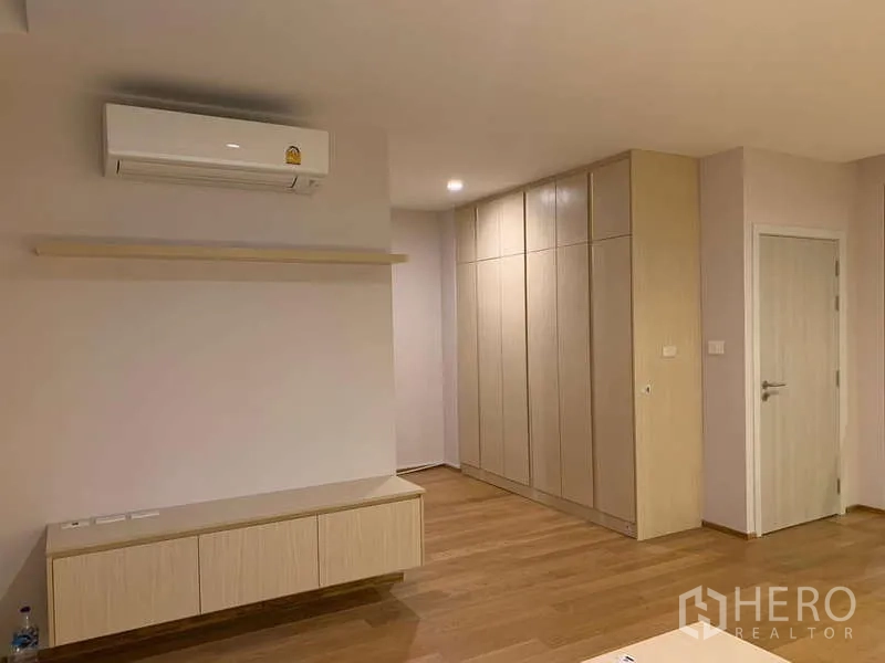 Townhouse for rent or sale in Saphan Sung, Bangkok - Spacious bedroom with AC, built-in wardrobe, floating cabinet and warm wood flooring.