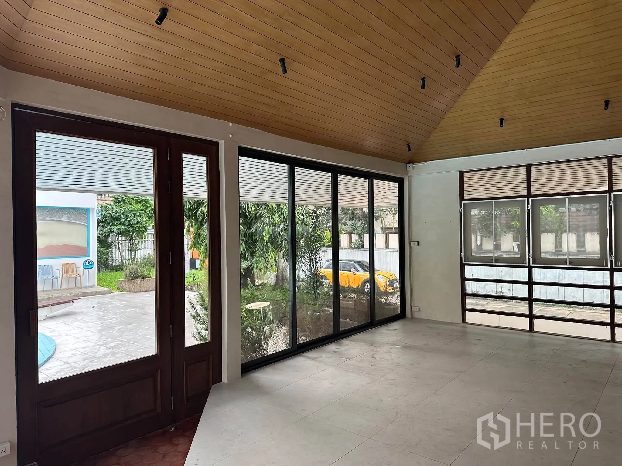 Retail Space for rent in Khlong Toei, Bangkok - Open retail room with large glass doors and windows facing garden views.