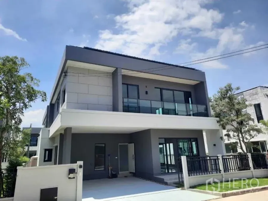 Detached House for rent in Bang Phli, Samut Prakan - Street view of a contemporary two-storey house with balcony and gated front yard.