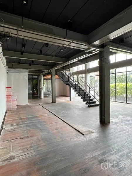 零售空间 出租在Watthana, Bangkok - 阁楼风零售大厅，落地窗与楼梯，面向绿植