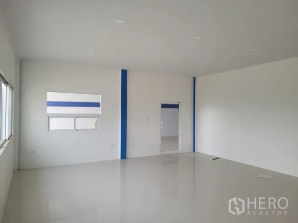 Factory for rent or sale in Khlong Luang, Pathum Thani - Bright office level with white walls, tiled flooring, and recessed lighting.