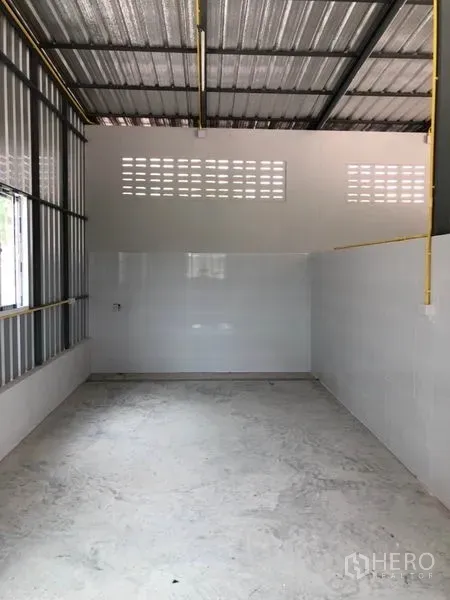 Warehouse for rent or sale in Thanyaburi, Pathum Thani - Clean warehouse interior with high steel roof, tiled walls and ventilation blocks.