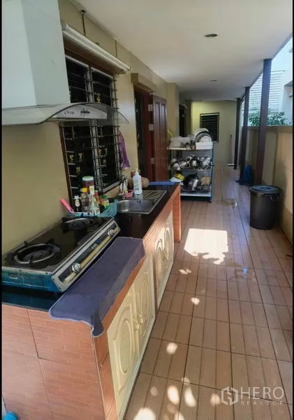 Detached House for sale in Bang Yai, Nonthaburi - Outdoor Thai kitchen with gas hob, extractor and tiled counter.