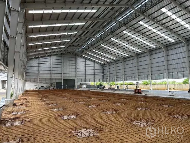 Warehouse for rent in Wang Noi, Phra Nakhon Si Ayutthaya - Large column-free warehouse interior with metal cladding and floor rebar installation.