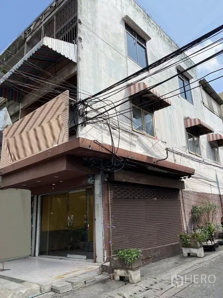 Retail Space for rent in Sathon, Bangkok - Corner shophouse exterior with glass shopfront and roll-up shutter on a side lane.