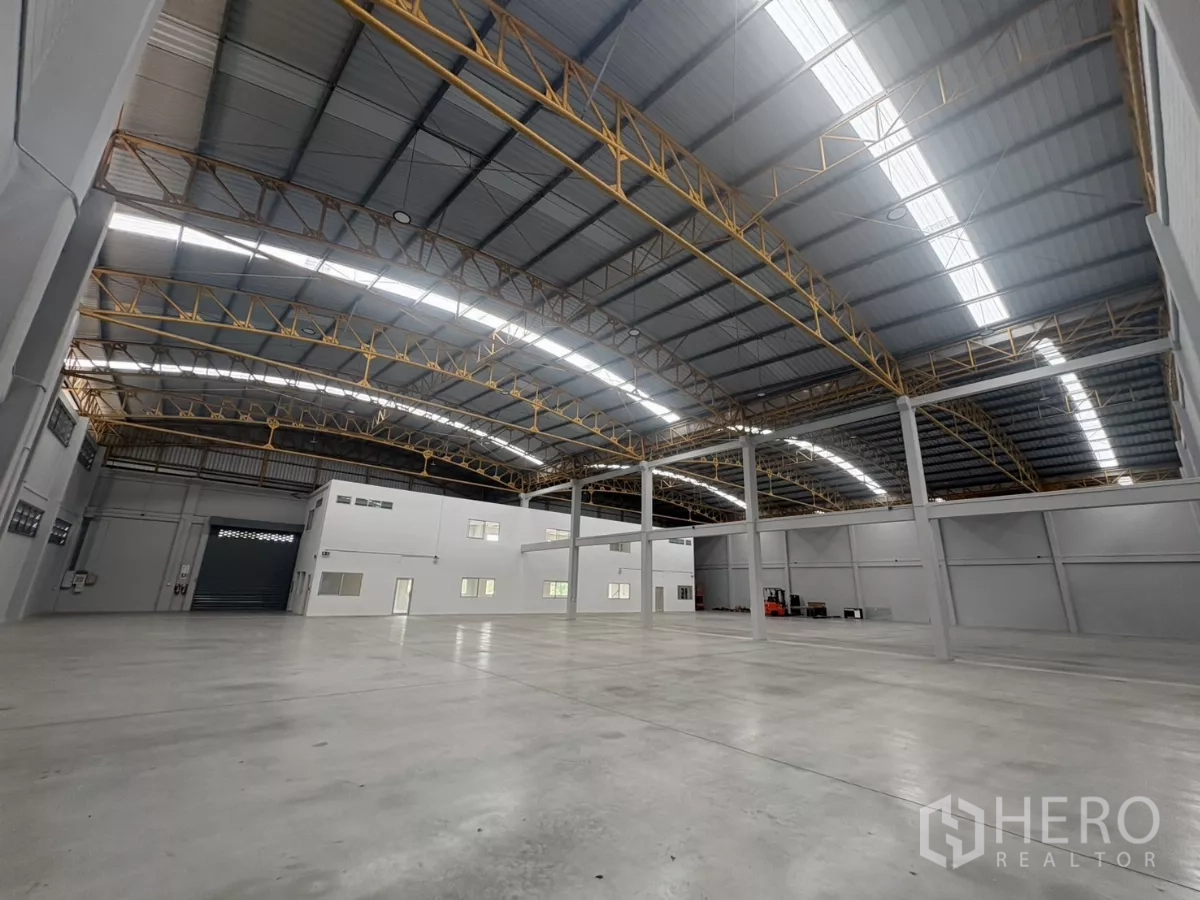 Factory for rent in Bang Phli, Samut Prakan - Expansive warehouse hall with tall columns and natural skylight strips.