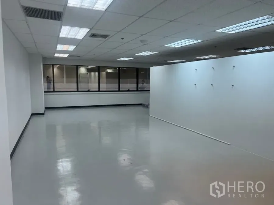 Office Space for rent - Spacious office area with a partition wall, window line and ceiling air-conditioning vents.