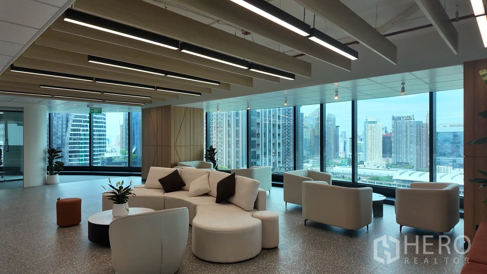 Office Space for rent in Din Daeng, Bangkok - Modern lounge area with curved sofas, coffee tables, and panoramic city views through large windows.