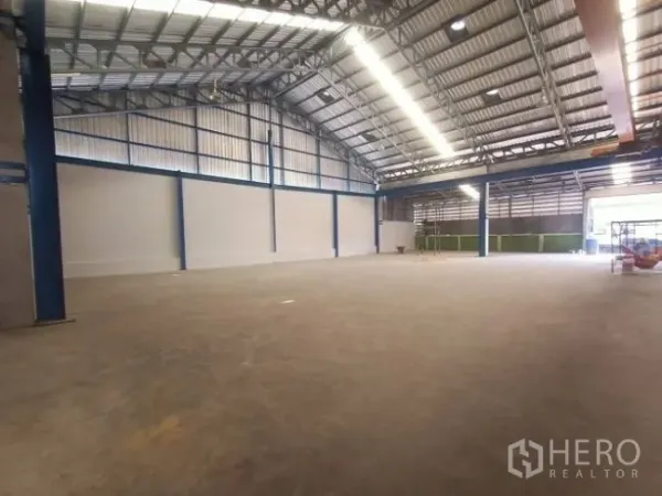 Factory for rent in Mueang Samut Sakhon, Samut Sakhon - Wide clear-span production floor under a high ceiling with steel beams and LED lighting.