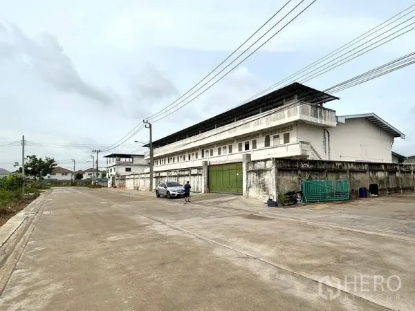 货栈 出租在Bang Khun Thian, Bangkok - 仓库门前宽阔的混凝土道路与围墙大门。