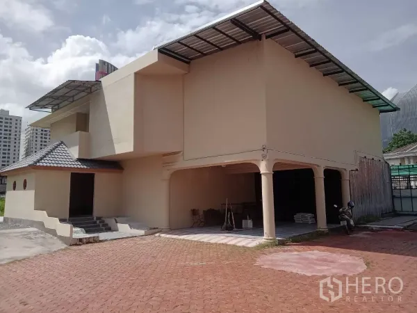 Detached House for rent in Phaya Thai, Bangkok - Front façade of the two-storey house with a covered carport and tiled roof.