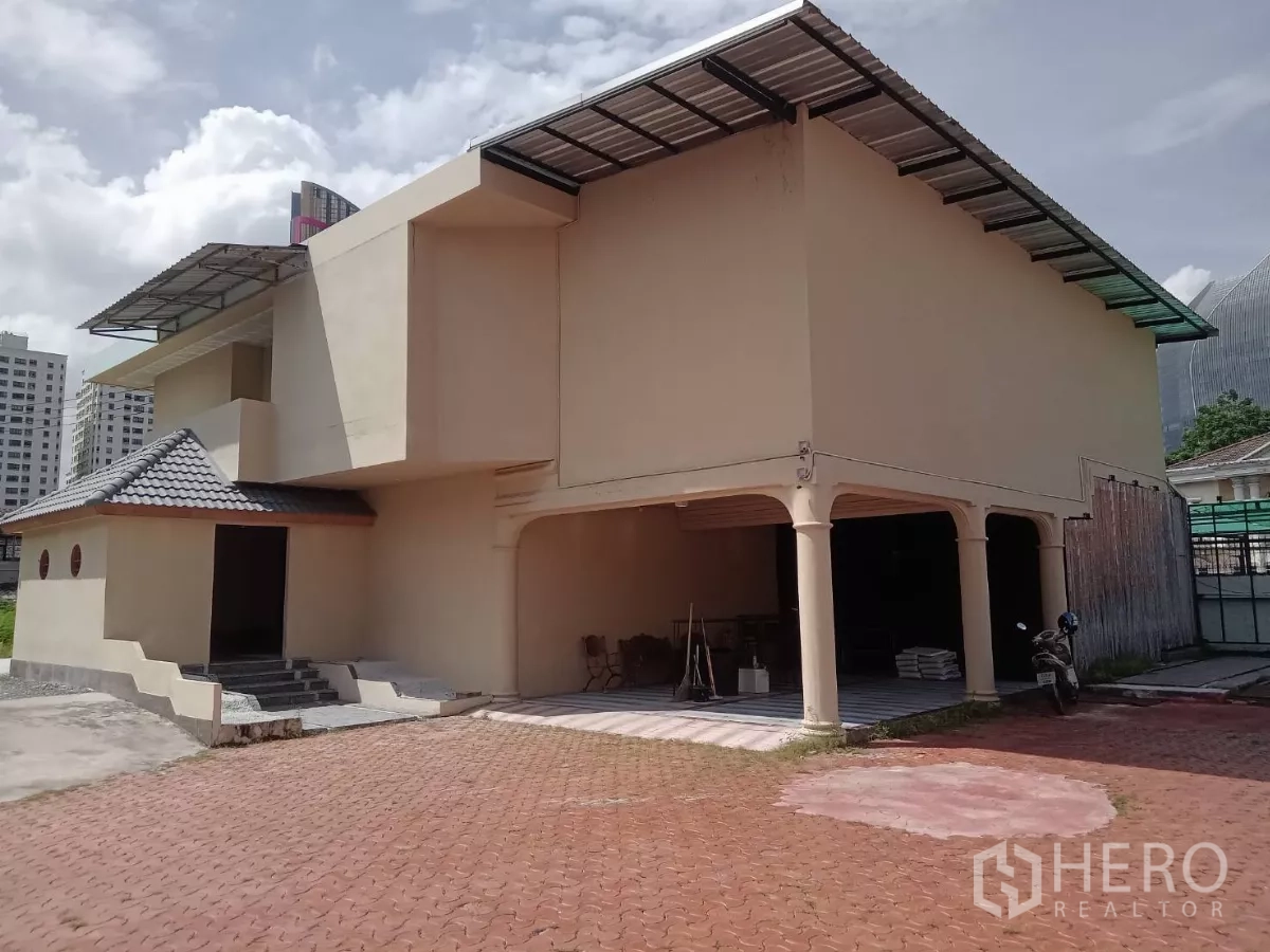 Detached House for rent in Phaya Thai, Bangkok - Front façade of the two-storey house with a covered carport and tiled roof.