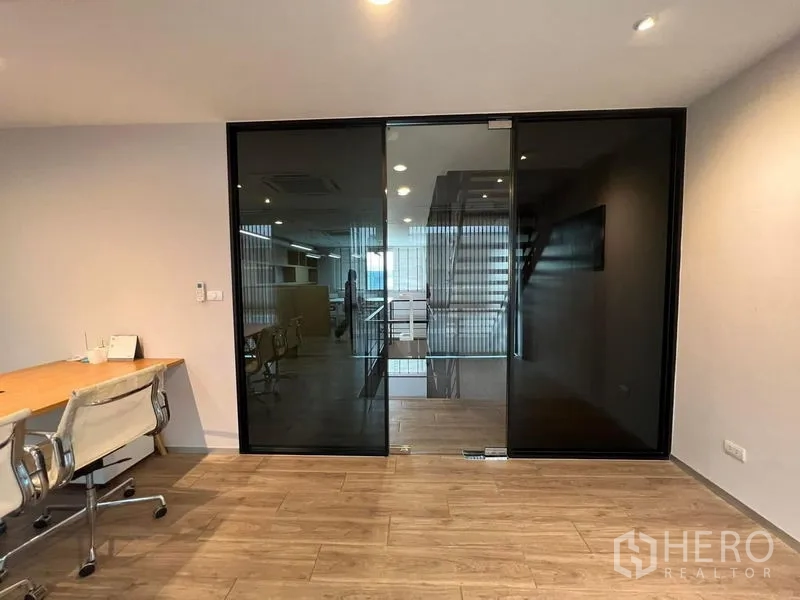 Home Office for rent in Bueng Kum, Bangkok - Private office behind dark glass sliding door with wood floors.