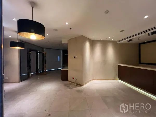 Retail Space for rent - Entrance zone with glass doors, ceiling spotlights, and a feature counter in a retail unit.