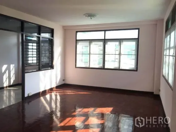 Detached House for rent in Chatuchak, Bangkok - Sunlit upper-floor room with large windows and polished wood flooring.