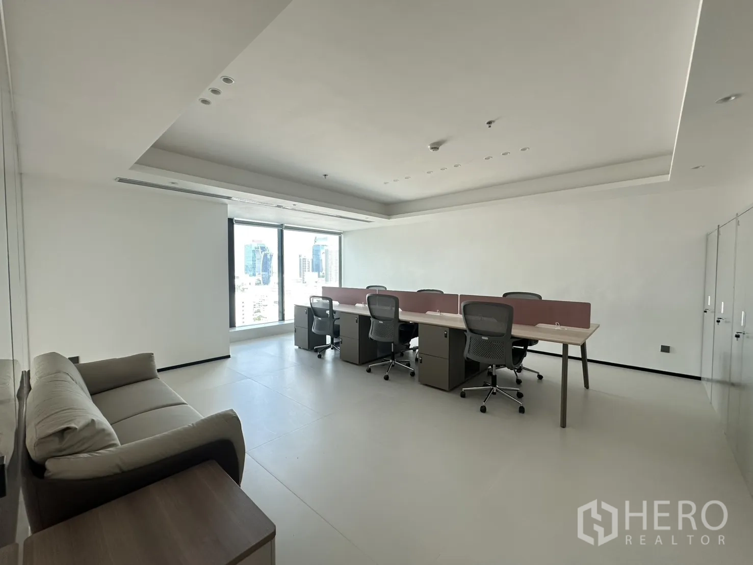 Office Space for rent in Din Daeng, Bangkok - Open-plan workspace with bench desks, task chairs, and a sofa by the window.