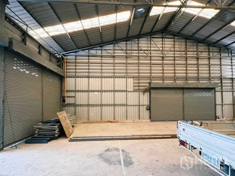 货栈 出租在Din Daeng, Bangkok - 工业仓内有双卷闸门与金属波纹墙面。