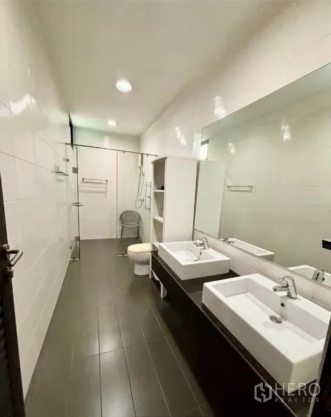 Home Office for rent in Watthana, Bangkok - Long bathroom with twin rectangular sinks, large mirror and a walk-in shower.