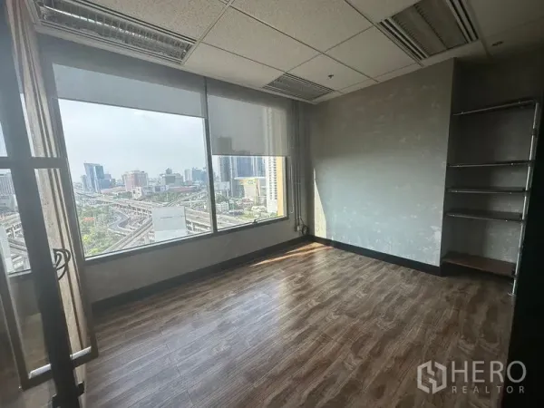 Office Space for rent in Chatuchak, Bangkok - Bright corner office with wood floors, large windows, and a wide skyline view over Chatuchak.