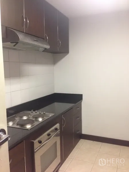 Condominium for rent in Pathum Wan, Bangkok - Separate cooking area with built-in oven, electric cooktop and range hood.