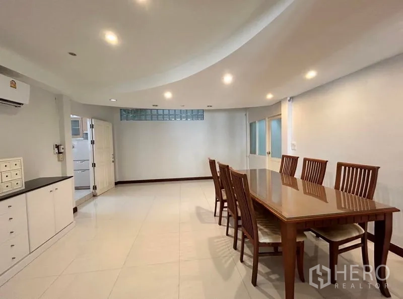 Home Office for rent in Suan Luang, Bangkok - Large dining room with recessed lighting and a long wooden table.