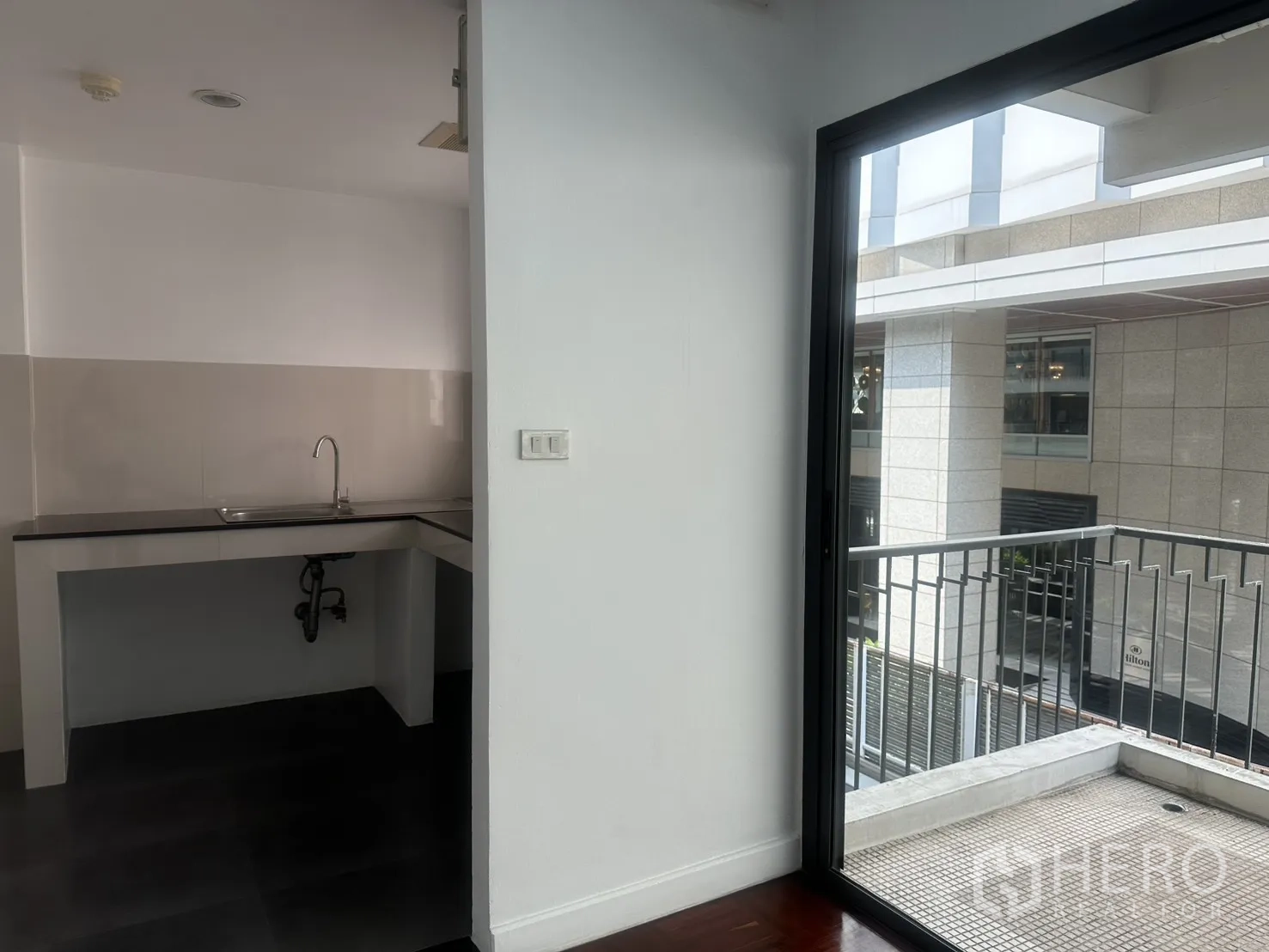 Office Space for rent in Watthana, Bangkok - Pantry entrance beside the balcony, with sliding door and exterior railing in view.