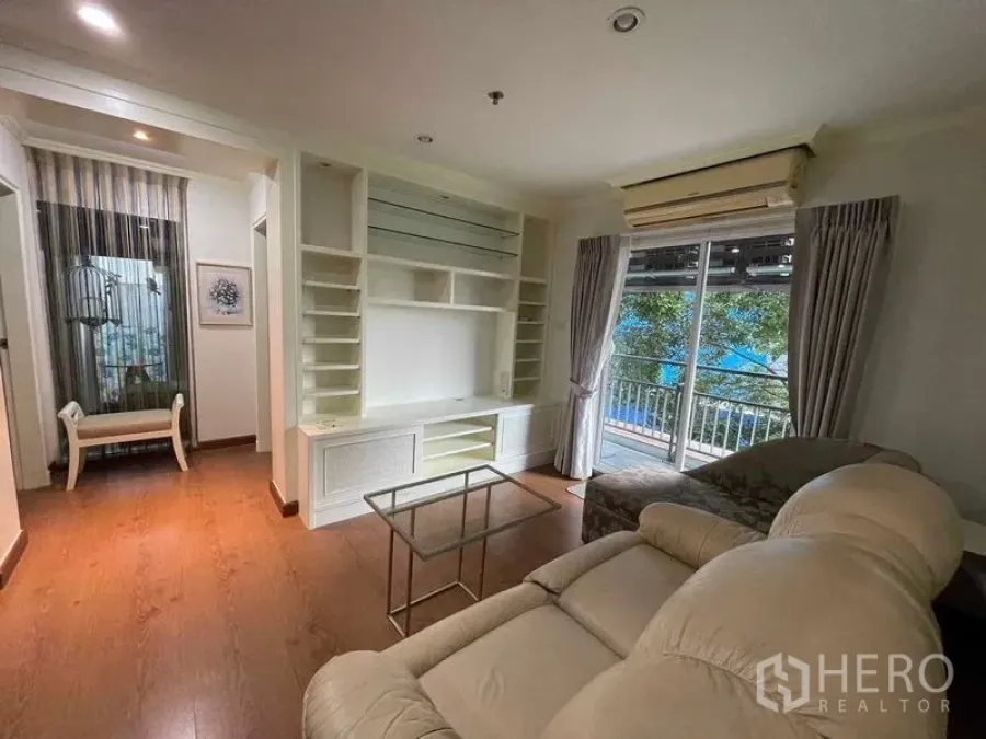 Condominium for rent - Another view of the living room with sofa, built-ins and balcony.
