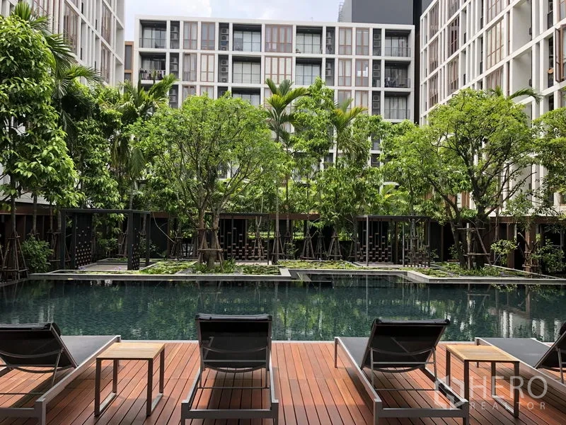 Condominium for rent in Watthana, Bangkok - Central courtyard swimming pool with sun loungers and lush trees.