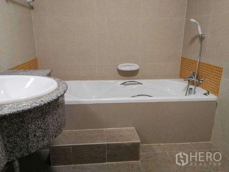 Home Office for rent in Khlong Toei, Bangkok - Bathroom featuring built-in bathtub, handheld shower and granite vanity.