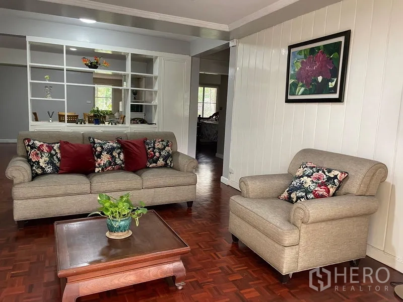 Condominium for rent in Watthana, Bangkok - Comfortable sitting area with sofa, armchair and floral cushions.