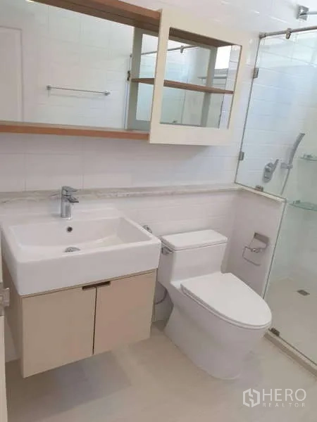 Detached House for rent in Sathon, Bangkok - Bright bathroom with square basin vanity, toilet, and glass-enclosed shower.