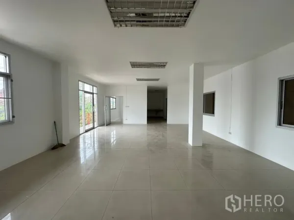 Factory for rent in Bang Sao Thong, Samut Prakan - Bright second‑floor office with tiled floors, multiple windows and glass doors to a balcony.