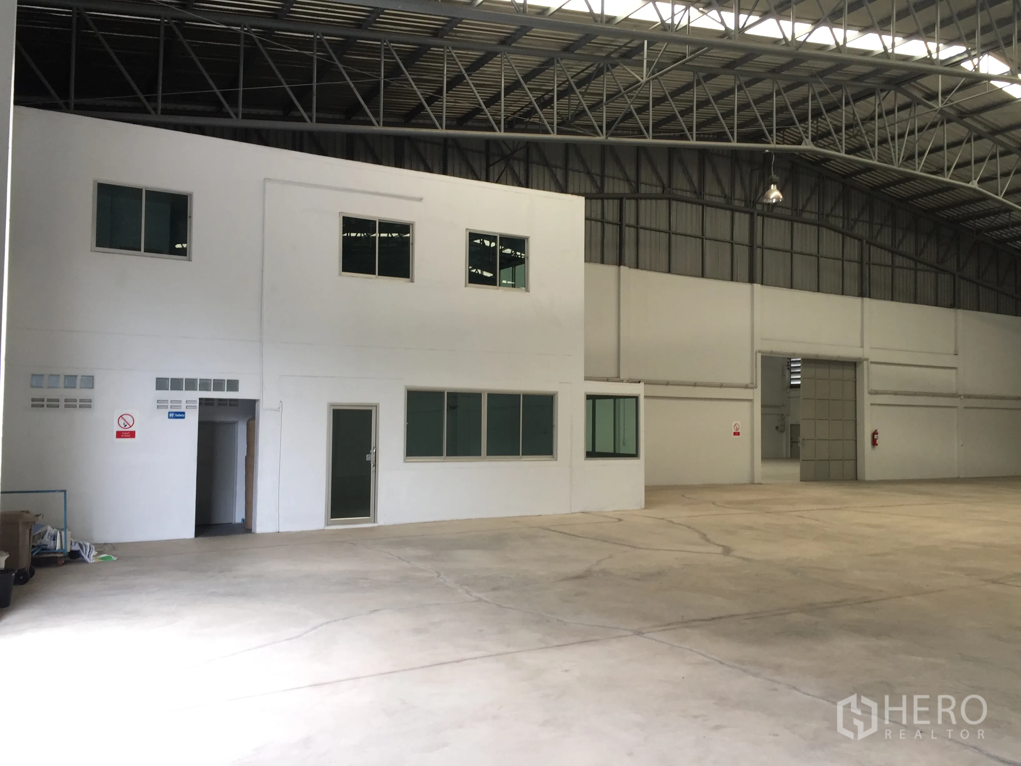 工厂 出租在Si Racha, Chon Buri - 厂内两层办公区，带窗户与门，毗邻大跨度仓储空间与高屋顶。
